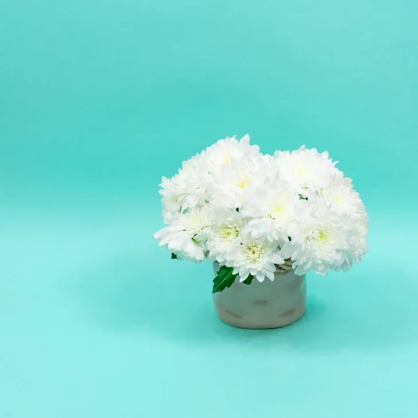 Ramo de crisantemos blancos en un jarrón de cerámica sobre fondo azul. Postales para el día de las madres, para el 8 de marzo. Hermosas flores de crisantemo. Lugar para una inscripción. — Foto de Stock