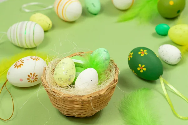 Nido de Pascua con huevos y plumas sobre un fondo verde de cerca. Concepto mínimo. — Foto de Stock
