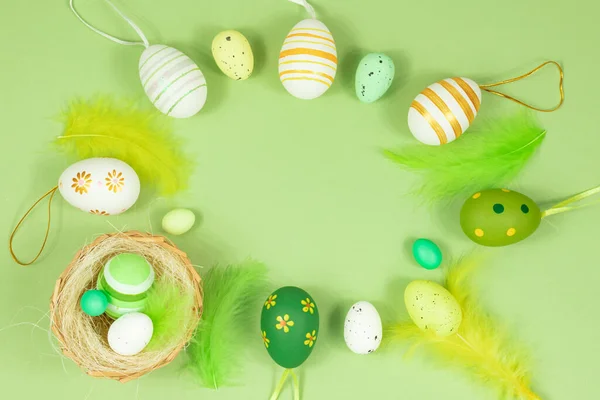 Feliz Pascua. Delicado fondo de ensalada pastel con un nido, huevos coloridos y plumas. Vista desde arriba. Lugar para el texto. — Foto de Stock