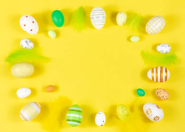 Cadre de Pâques avec œufs et plumes sur fond jaune. Concept minimal. Vue d'en haut. Carte avec espace de copie pour le texte. — Photo