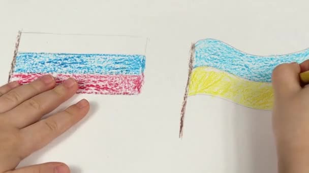 Les mains d'enfant d'un enfant tirent les drapeaux de l'Ukraine et de la Russie en gros plan. Vue d'en haut. Les enfants dessinent pour la paix en Ukraine. — Video