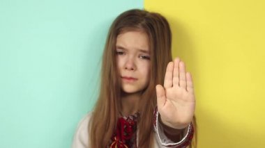 Ukraynalı küçük kız DUR 'u eliyle gösteriyor. Ukrayna 'daki savaşı durdurun. Savaşa karşı çocuklar.