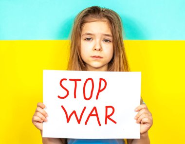 Bir kız ağlıyor, elinde Ukrayna bayrağının arka planına karşı bir DUR Savaş posterini tutuyor. Ukrayna 'daki savaşı durdurun. Ukrayna 'da barış kavramı. Yazı metni için yer