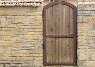 Wooden antique door in a stone wall. Place for an inscription. Copy Space