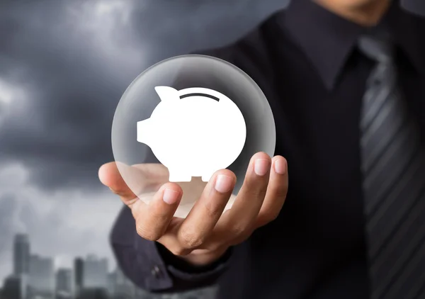 Piggy bank protected by crystal ball in hand — Stock Photo, Image