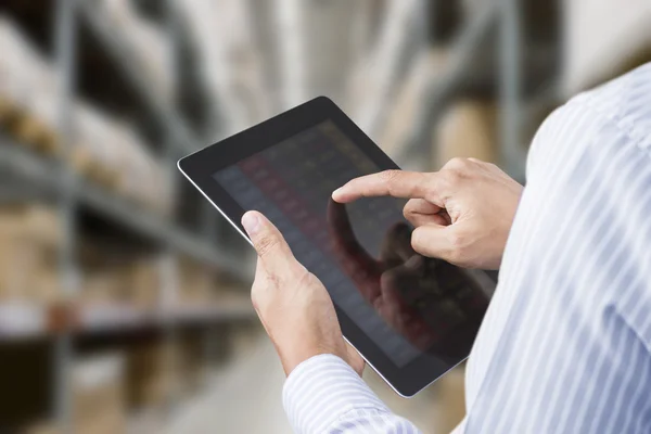 Hombre de negocios que comprueba el inventario en la sala de stock en la tableta de pantalla táctil — Foto de Stock