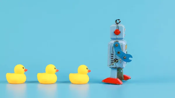 复古机器人和黄色橡胶浴场鸭 领导理念 免版税图库图片