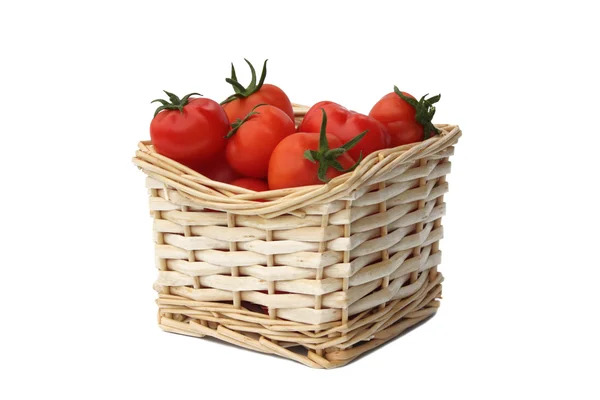 Tomates rojos maduros en una cesta arrugada aislada sobre un fondo blanco — Foto de Stock