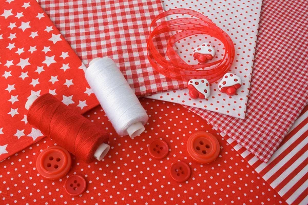 Accessories for sewing: threads, fabric, buttons in red-white co — Stock Photo, Image