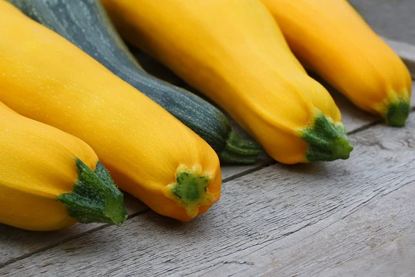 Four brightly yellow zucchini vegetable marrows and one green st — Stock Photo, Image