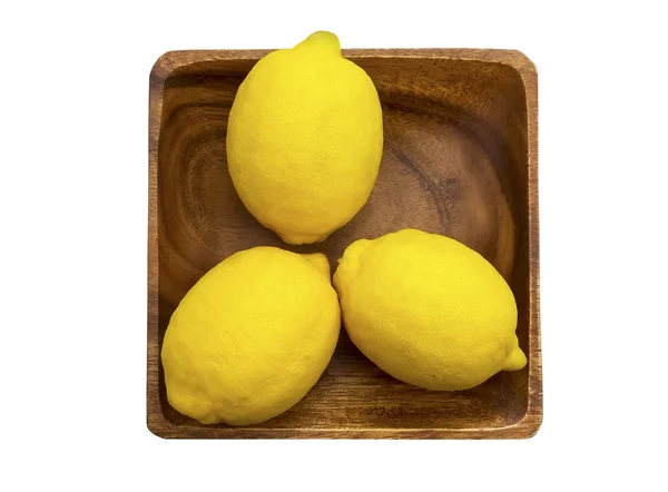Three fresh lemons on a wooden plate — Stock Photo, Image