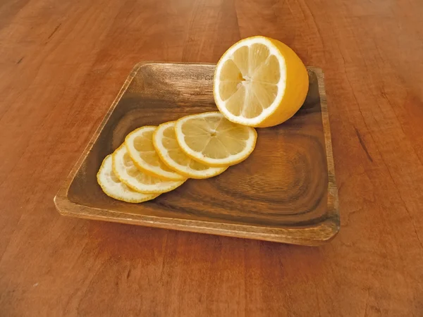 Frische, in Scheiben geschnittene Zitrone in einer Holzschale — Stockfoto