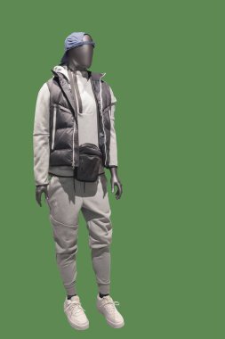 Yeşil arka planda izole edilmiş, yumuşak yastıklı ceket giyen bir erkek mankenin tam boy görüntüsü.