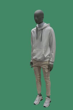 Yeşil arka planda izole edilmiş günlük kıyafetler giyen bir erkek vitrin mankeni.