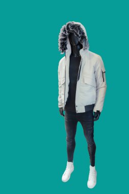 Beyaz kapüşonlu ve yeşil arka planda izole edilmiş siyah yırtık kot giyen bir erkek vitrin mankeni.