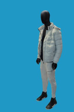 Mavi arka planda beyaz kapüşonlu bir erkek mankenin tam boy görüntüsü.