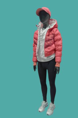 Moda çocukların giydiği, yeşil arka planda izole edilmiş bir çocuk mankeninin tam boy görüntüsü