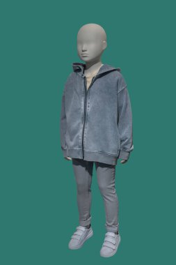 Yeşil arka planda izole edilmiş kapüşonlu ceket giyen bir çocuk mankeni..