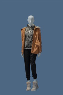 Mavi arka planda izole edilmiş sıcak moda kıyafetler giyen bir kadın vitrin mankeninin tam boy görüntüsü.