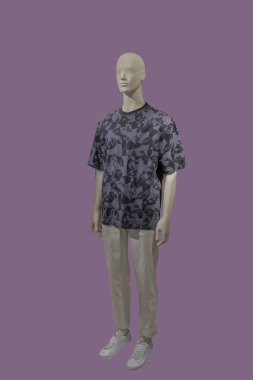 Tam boy erkek manken. Mor arka planda izole edilmiş günlük yaz kıyafetleri giyiyor..