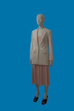 Mavi arka planda izole edilmiş şık kıyafetler giyen bir kadın vitrin mankeni..