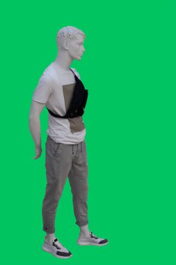 Yeşil arka planda izole edilmiş günlük kıyafetler giyen bir erkek vitrin mankeni.