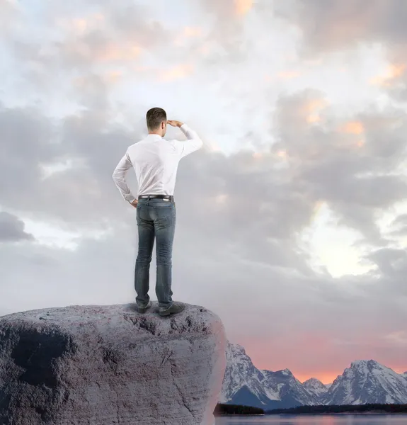 Businessman standing on rock — Stock Photo, Image