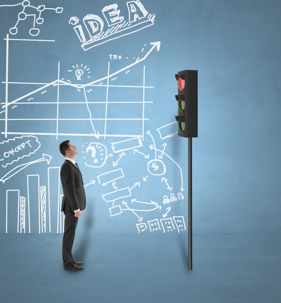 Businessman looking at traffic light — Stock Photo, Image