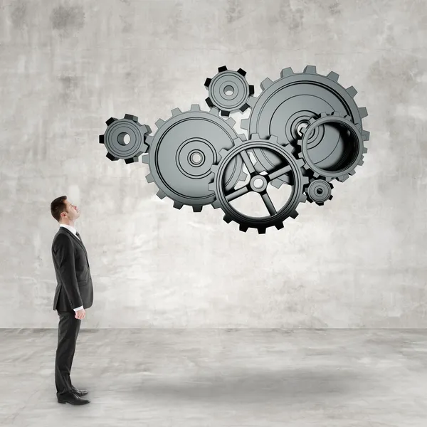 Businessman looking at  gears — Stock Photo, Image