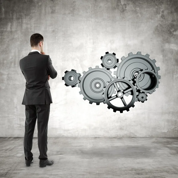 Businessman looking at  gears — Stock Photo, Image