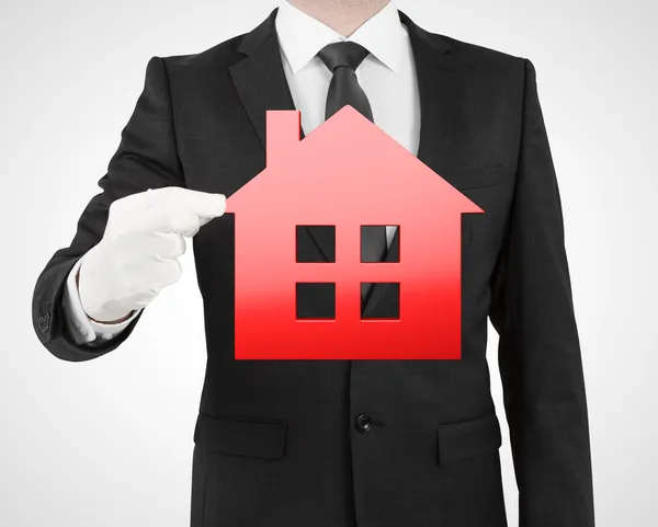 Businessman holding red house — Stock Photo, Image
