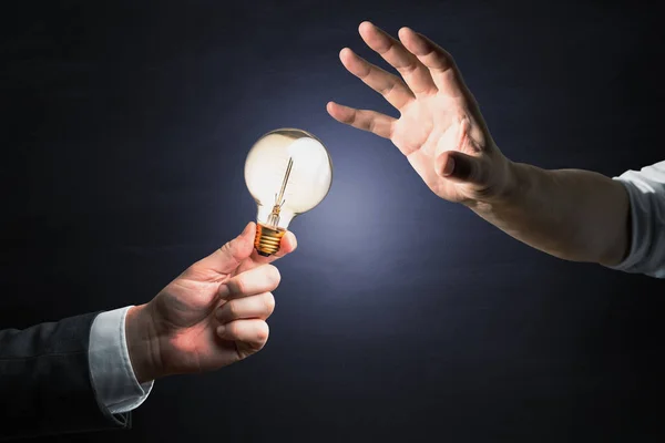 Geschäftsleute Reichen Glühbirnen Auf Dunklem Hintergrund Inspiration Und Teamwork — Stockfoto