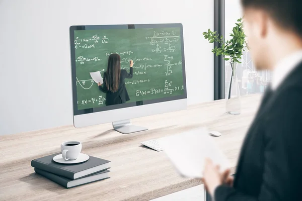 オフィスの机でヨーロッパのビジネスマンは オンライン教育の黒板や数式のパターンを持つコンピュータ画面を見て デジタル知識とウェビナーのコンセプト — ストック写真