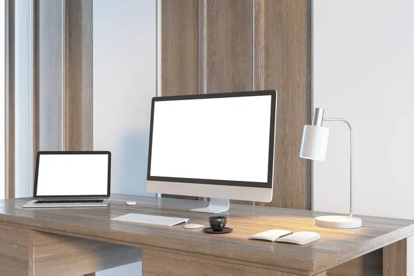 Simple designer desktop with empty white computer and laptop screens in wooden interior in daylight. Workplace concept. Mock up, 3D Rendering