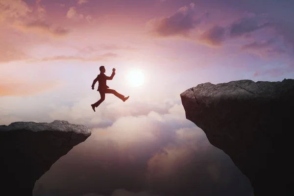 Бизнесмен Прыгает Скалы Красивом Фоне Неба Подъем Прыжок Риск Вызов — стоковое фото