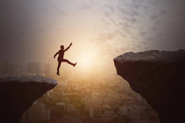 Бизнесмен Прыгает Скалы Красивом Небе Городском Фоне Подъем Прыжок Риск — стоковое фото