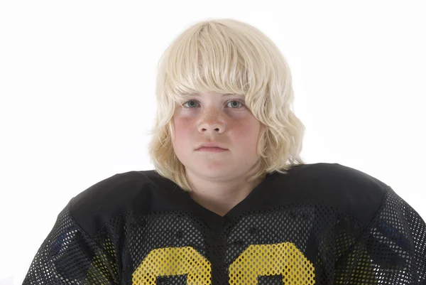 Ξανθό αγόρι στο αμερικανικό ποδόσφαιρο ομοιόμορφο με μαύρη φανέλα και μακριά μαλλιά — Φωτογραφία Αρχείου