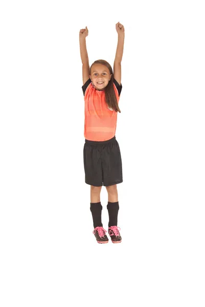 Menina em futebol uniforme de futebol pulando para cima de alegria — Fotografia de Stock