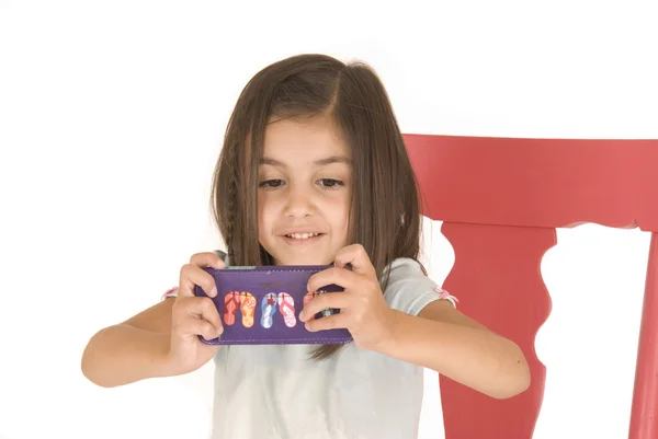 Young girl playing game on purple cell phone — Stock Photo, Image