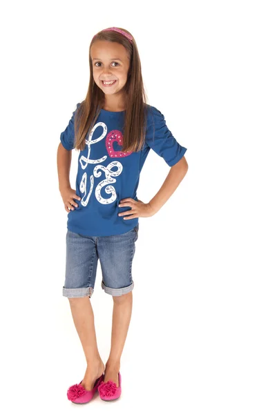 Милая юная брюнетка стоит с руками на бедрах в голубой футболке — стоковое фото