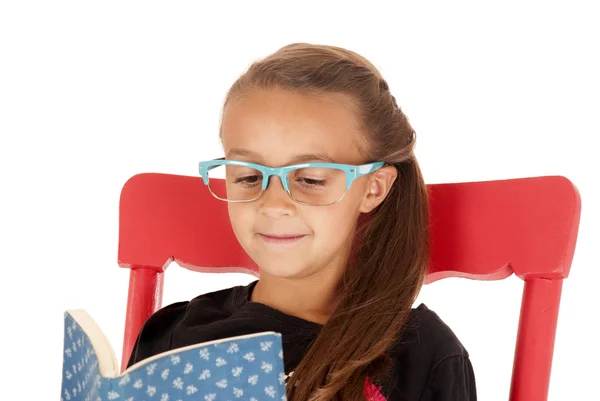 Νεαρό κορίτσι σε μοντέρνα μπλε γυαλιά, διαβάζοντας ένα βιβλίο — Φωτογραφία Αρχείου