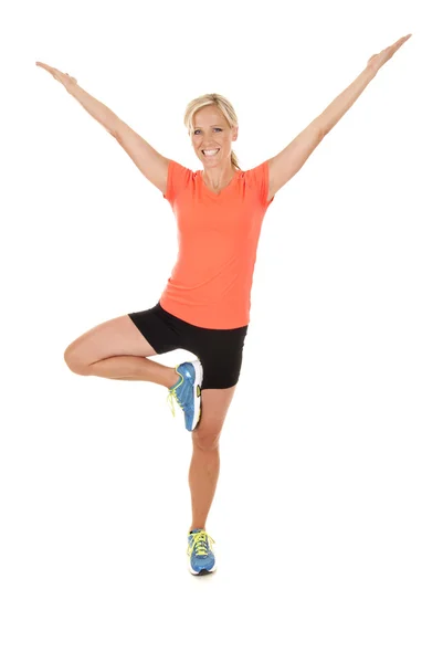 Attractive woman in orange top working out arms stretched — Stock Photo, Image