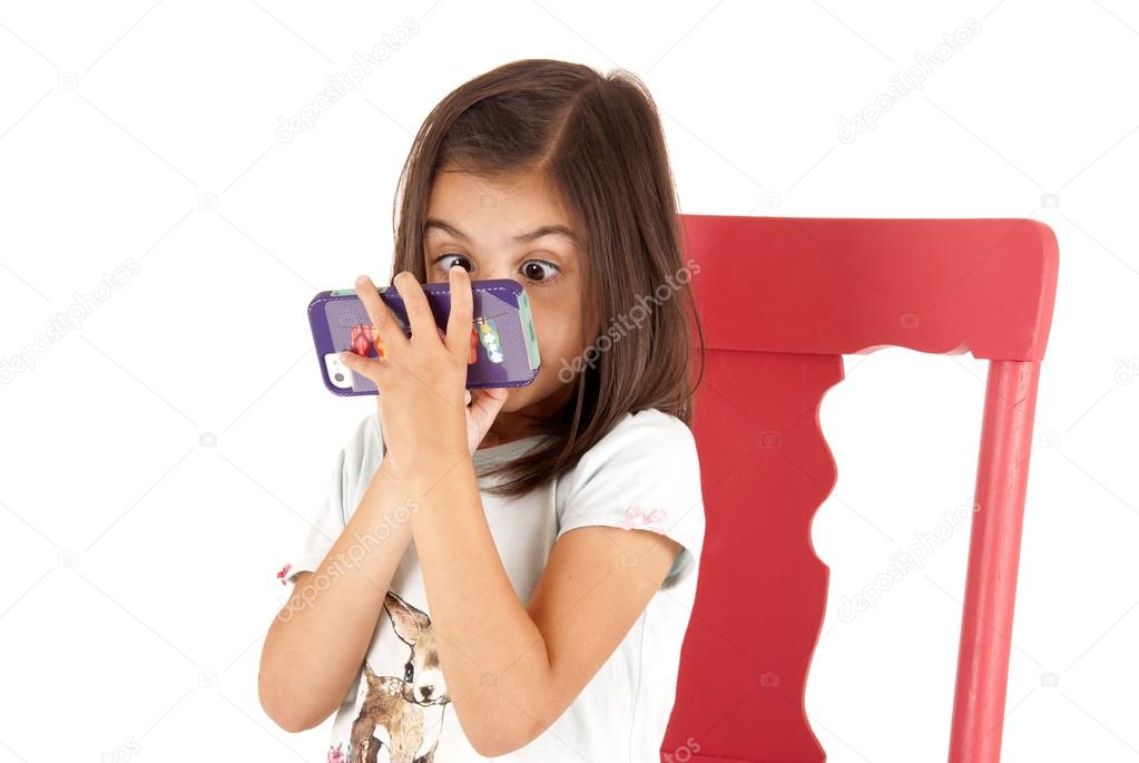 Girl with wide eyed expression playing game on phone