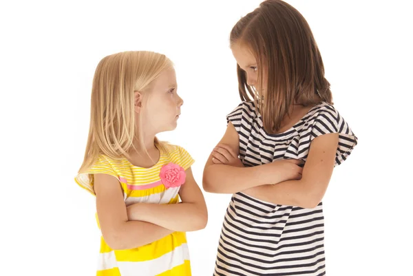 Two sisters with arms folded angry looking at each other — Stock Photo, Image