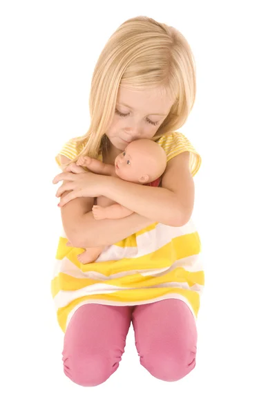 Χαριτωμένο ξανθιά νεαρή κοπέλα που παίζει με μια κούκλα μωρό — Φωτογραφία Αρχείου