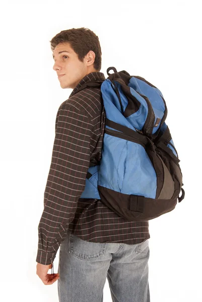 Avslappnad klädd ung man med blå ryggsäck ser över axelklaffa — Stockfoto