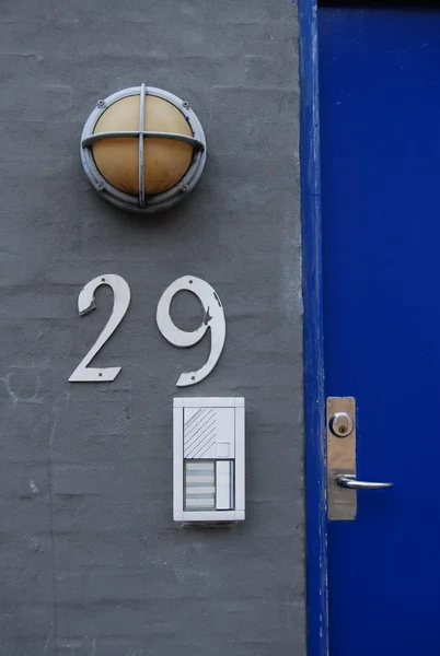 Porta azul pitoresca e casa cinza número 29 teclado e luz — Fotografia de Stock