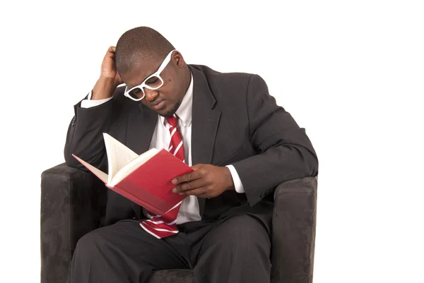 Young executive in suit sitting in chair reading intensely — Stock Photo, Image