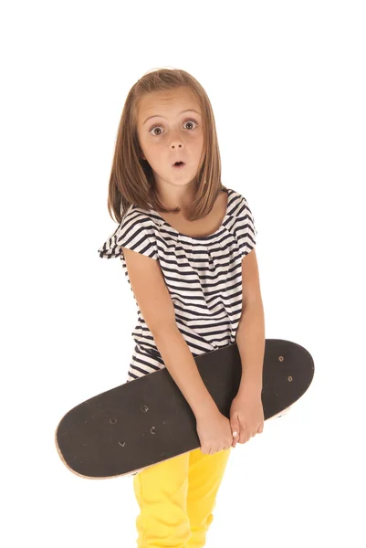 Young girl holding a skate board with a surprised look on her fa — Stock Photo, Image