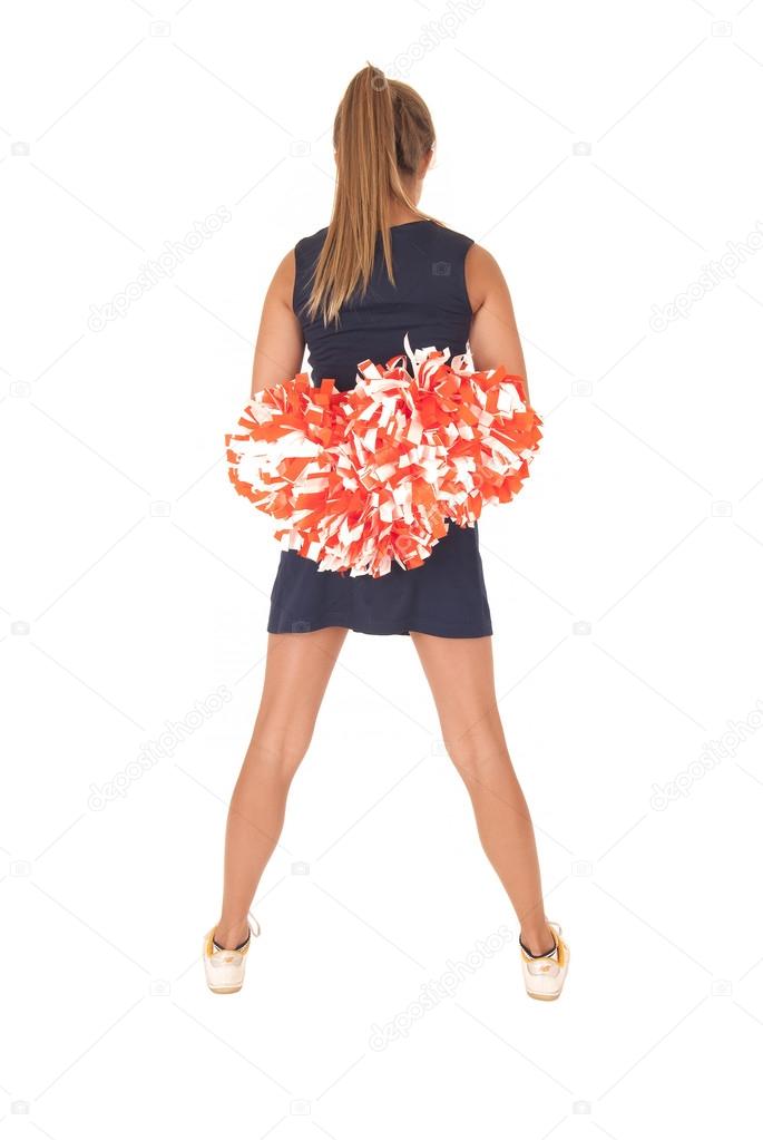 Young cheerleader standing with back to camera has pom poms